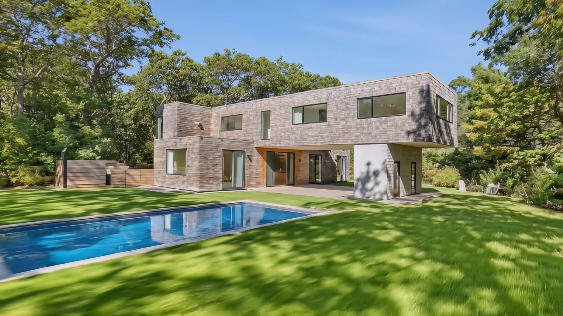 Aerial view of house exterior with pool and lush landscaping