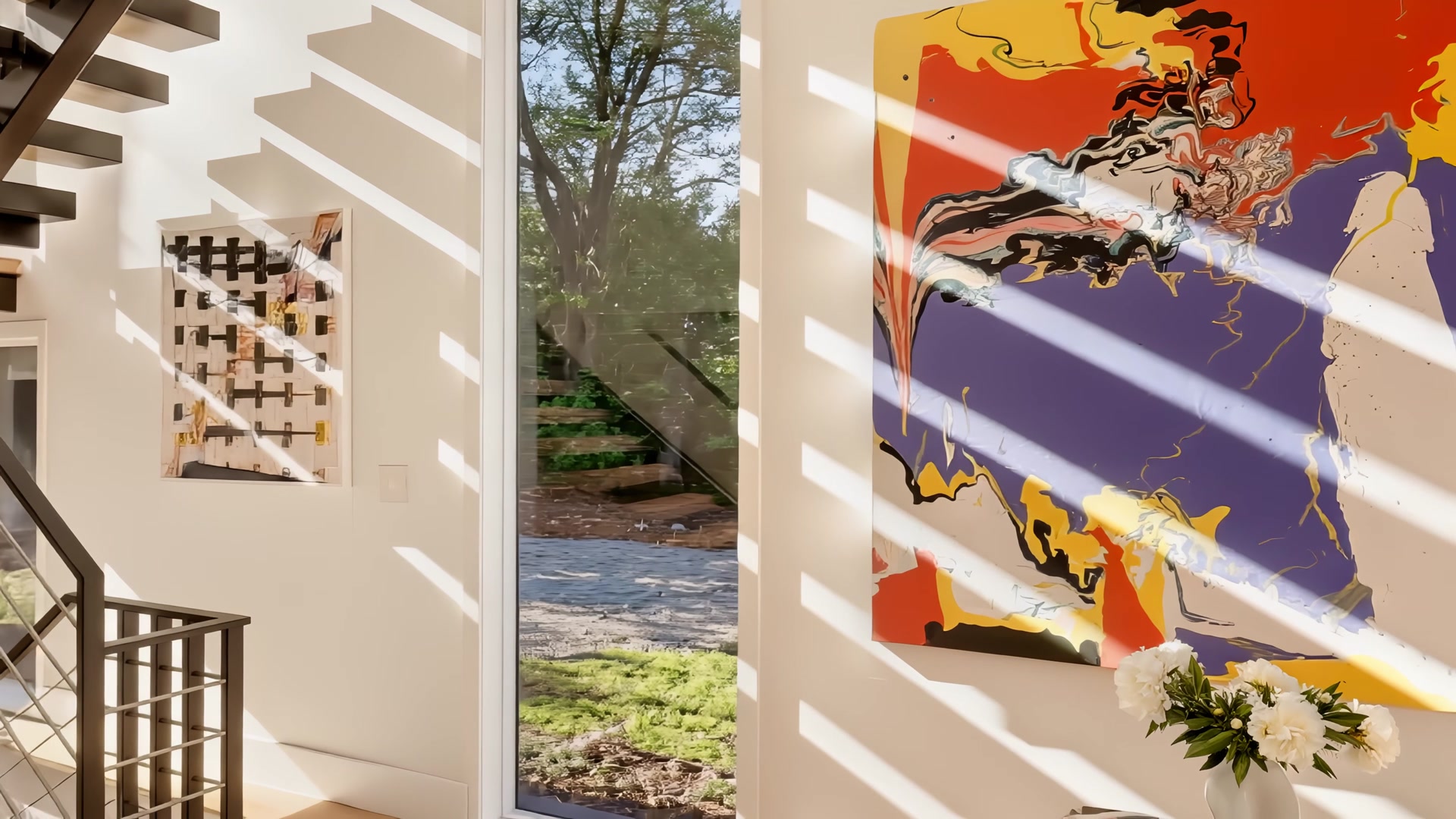 Custom floating steel staircase with large-scale contemporary paintings and natural light