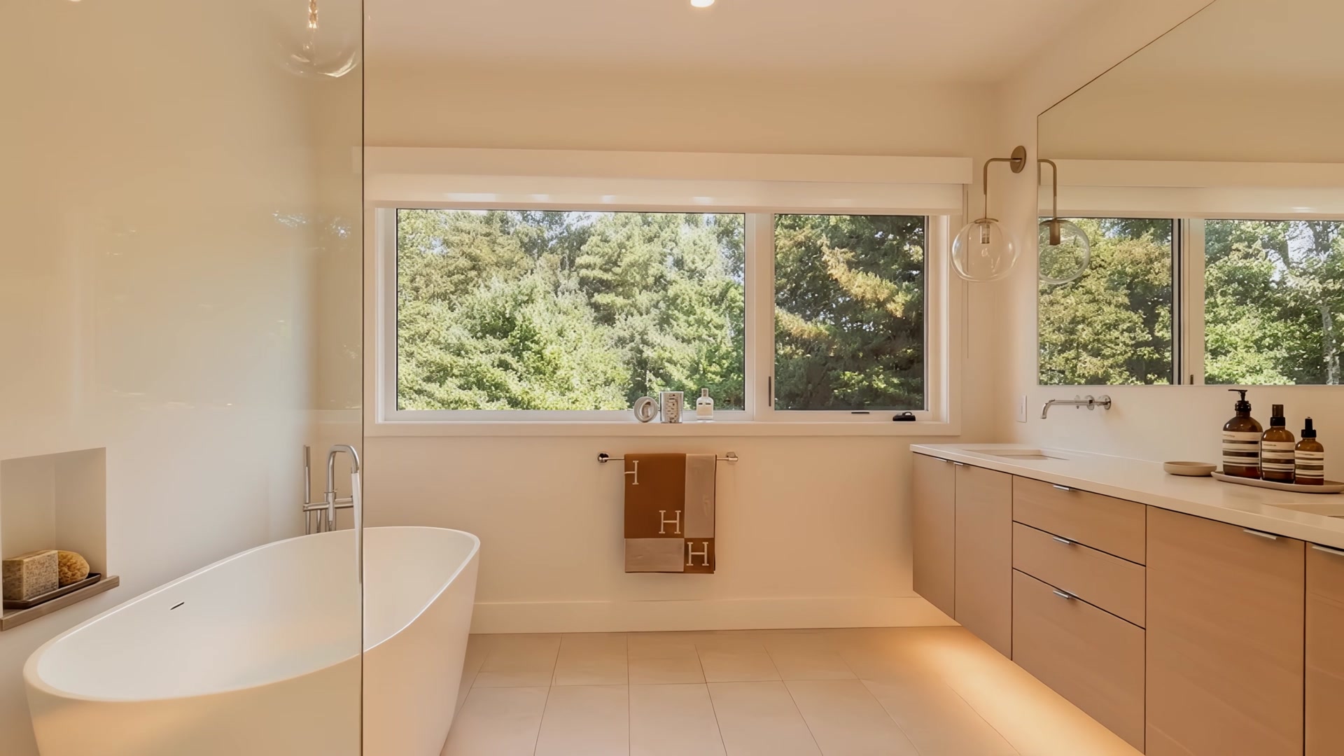 Bright spa-like bathroom with freestanding soaking tub and garden view